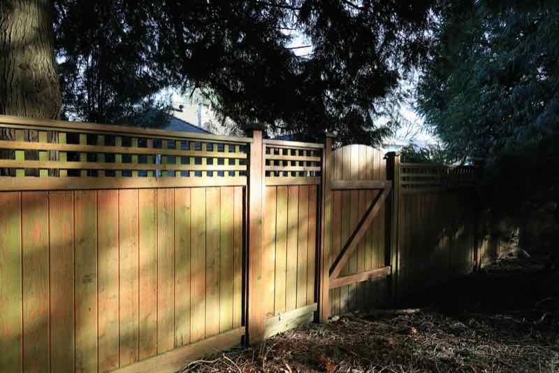 Wood privacy fence with a matching gate and lattice top